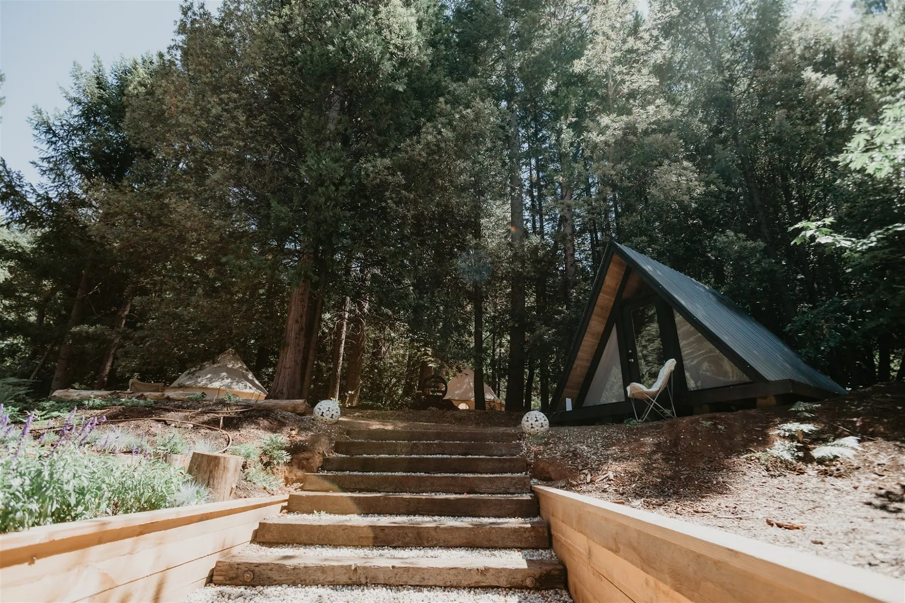 Stone steps climbing the hillside toward the A-frame cabin