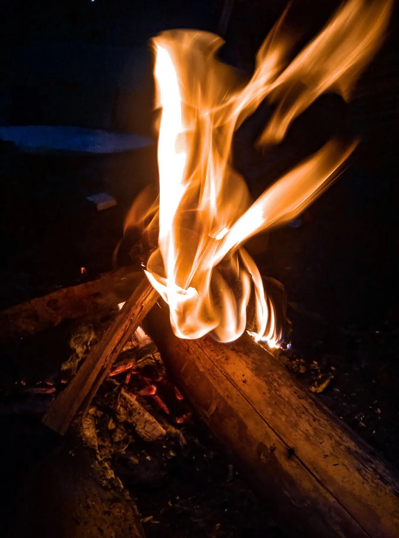 Flames rising from a campfire at night