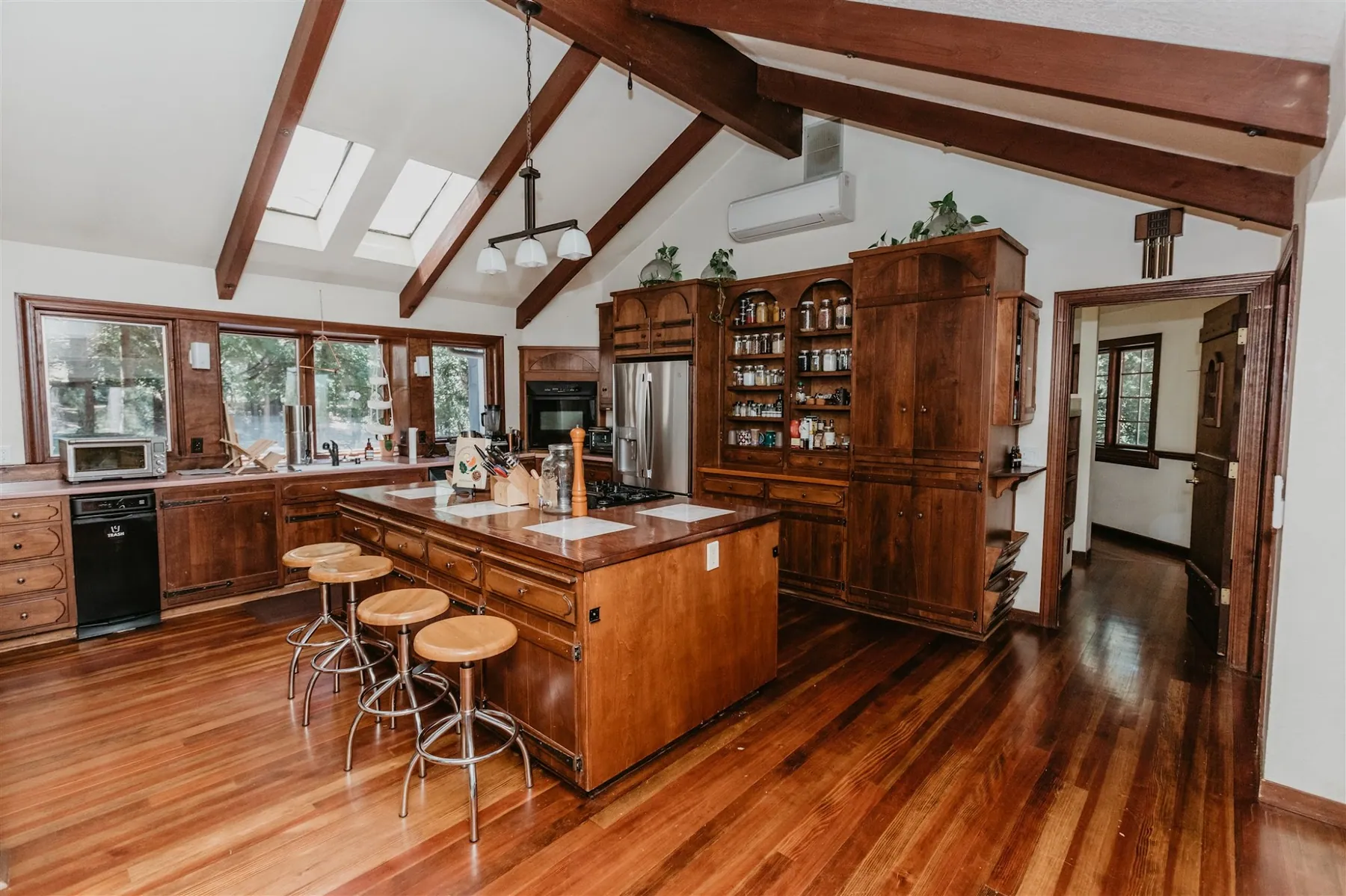 The lodge kitchen in warm wood, with a central island, bar stools and skylights overhead