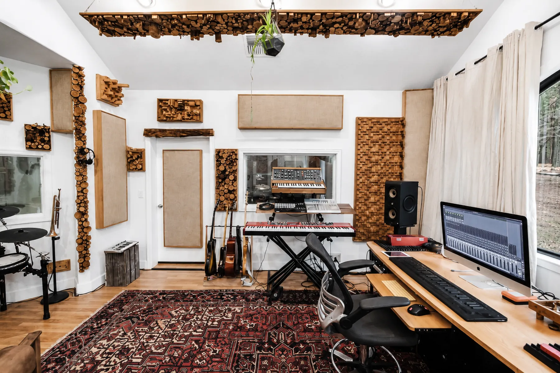 A live room at Madrone Studios with acoustic treatment, studio monitors and a workstation