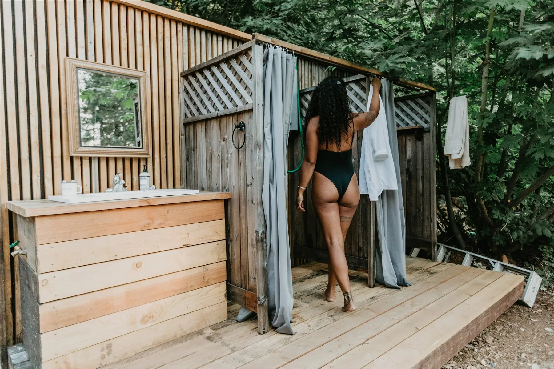 A guest stepping onto the cedar deck of the open-air shower