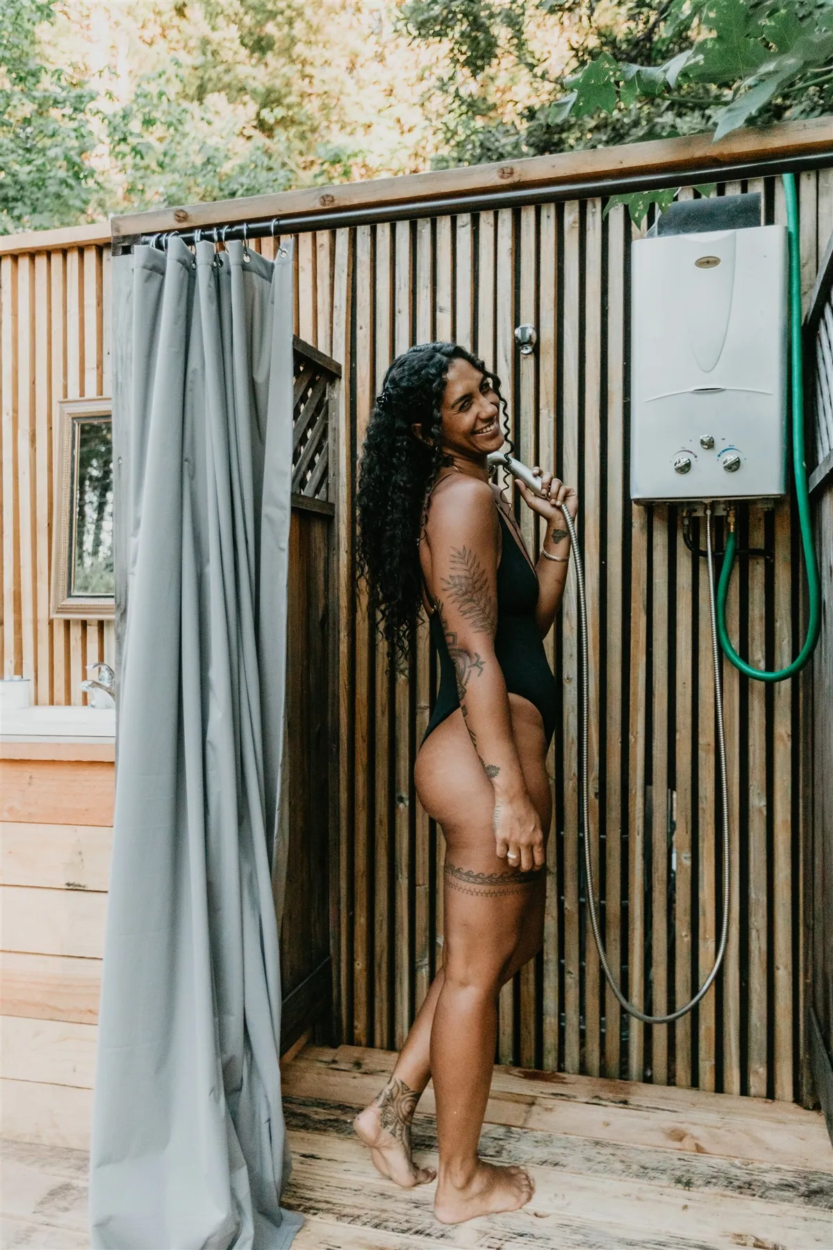 The open-air shower against a cedar wall, surrounded by trees
