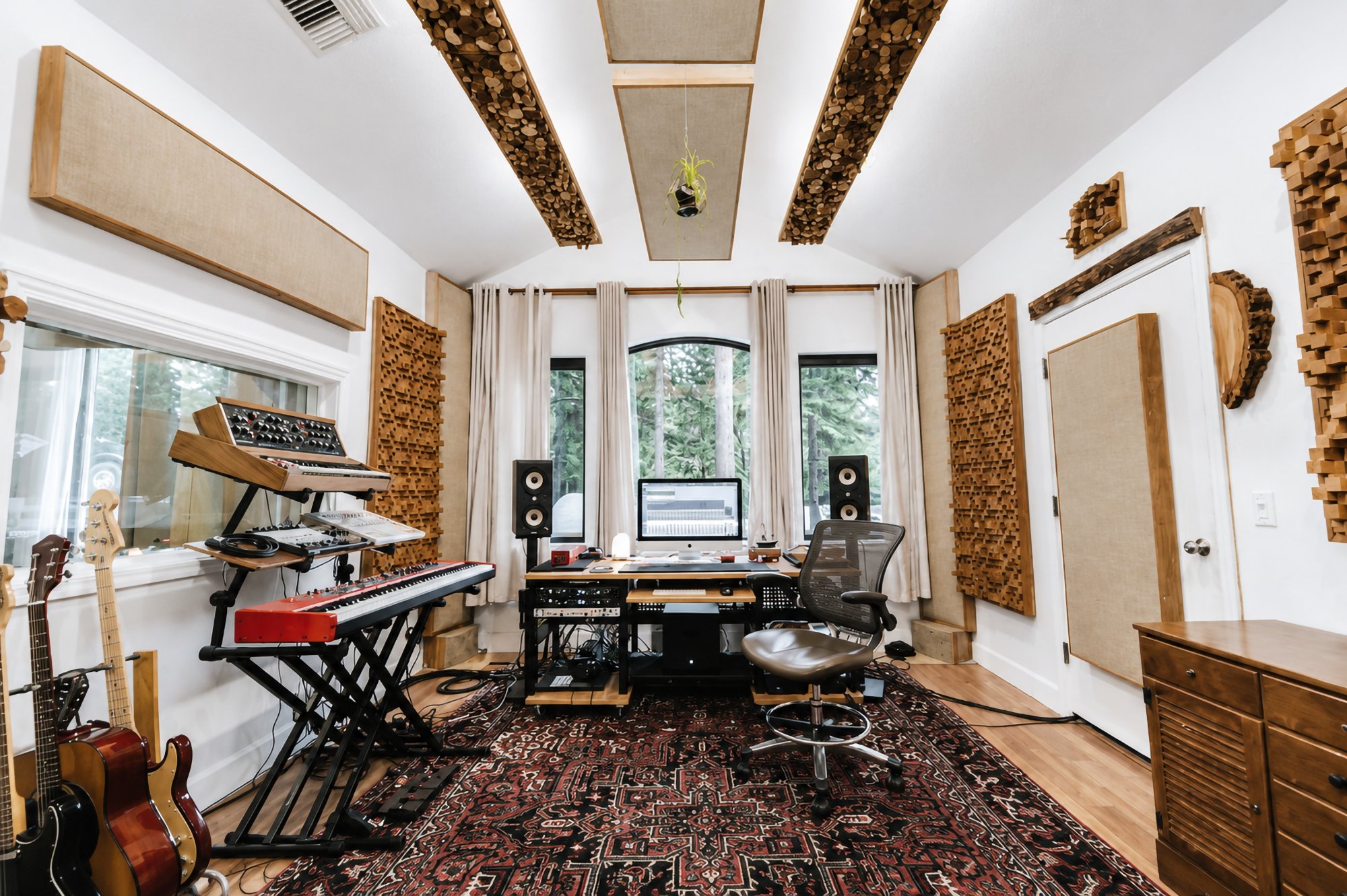 The desk built into the bay window, keyboards and guitars along the wall