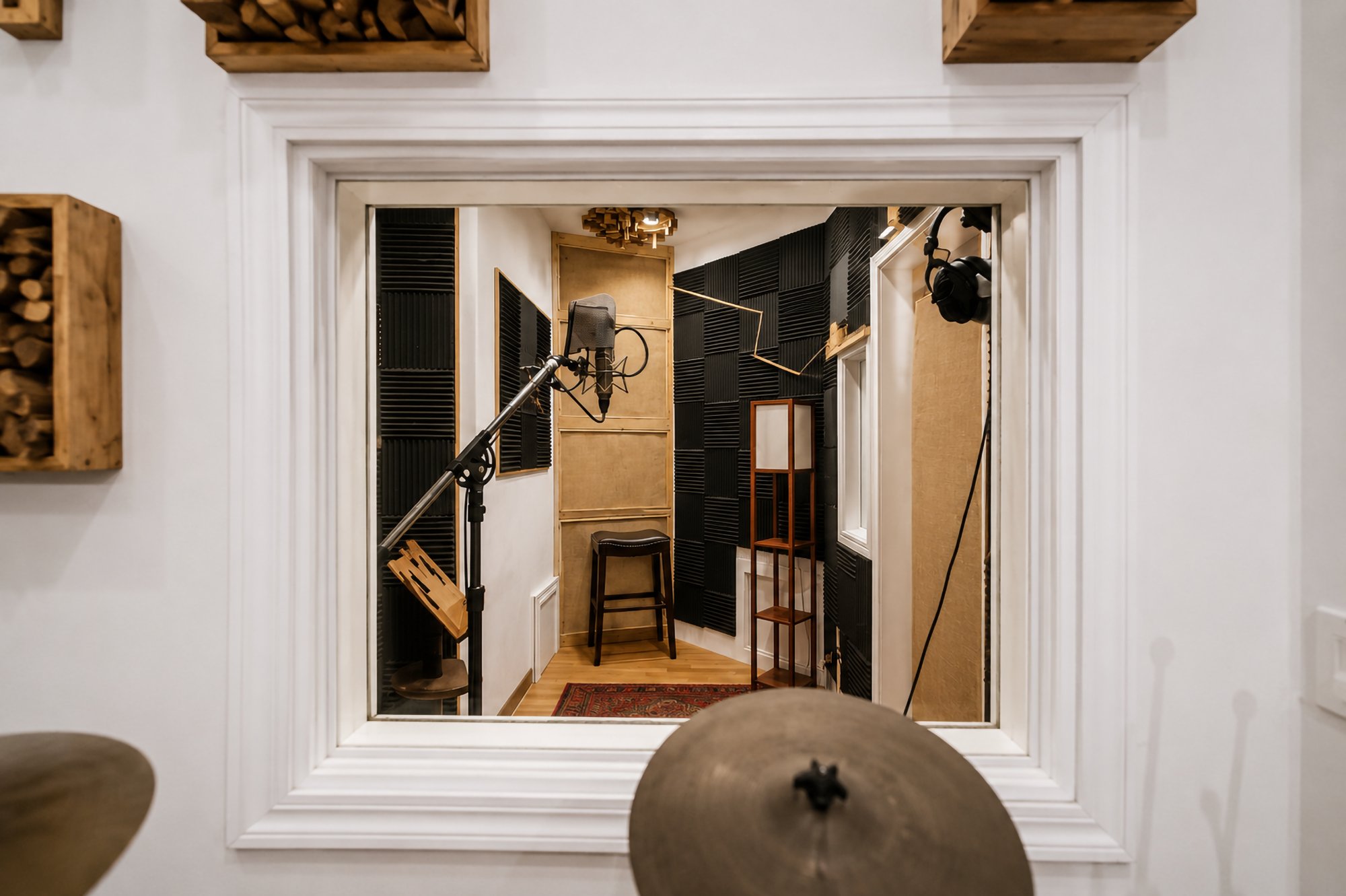 The vocal booth seen through the glass, a cymbal in the foreground
