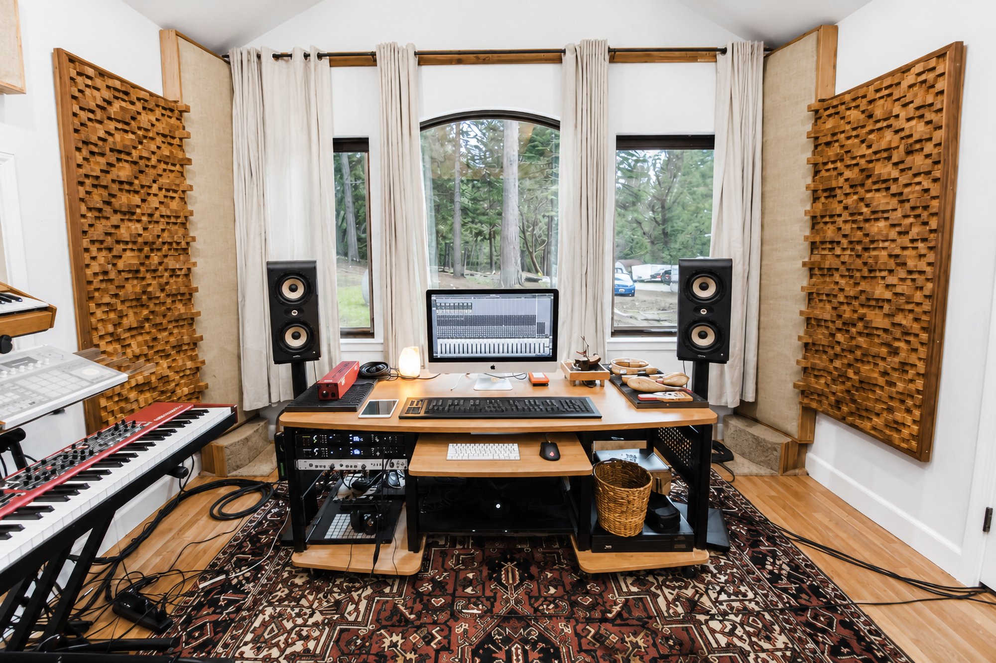 The mixing desk set between studio monitors, bay windows behind