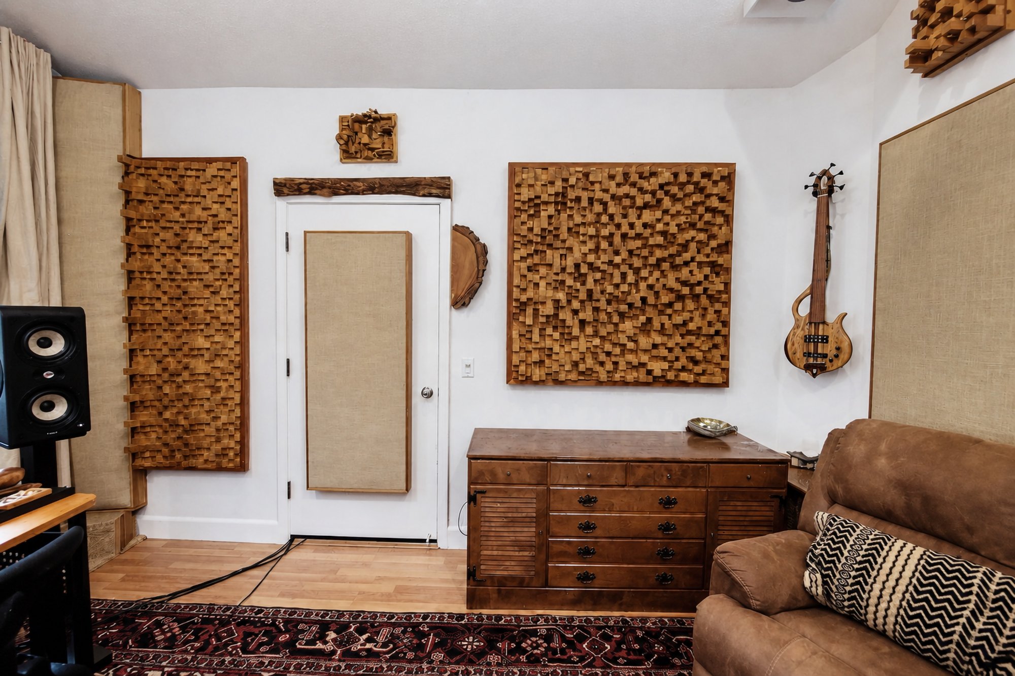 Wood diffuser panels and a chest of drawers between two leather armchairs