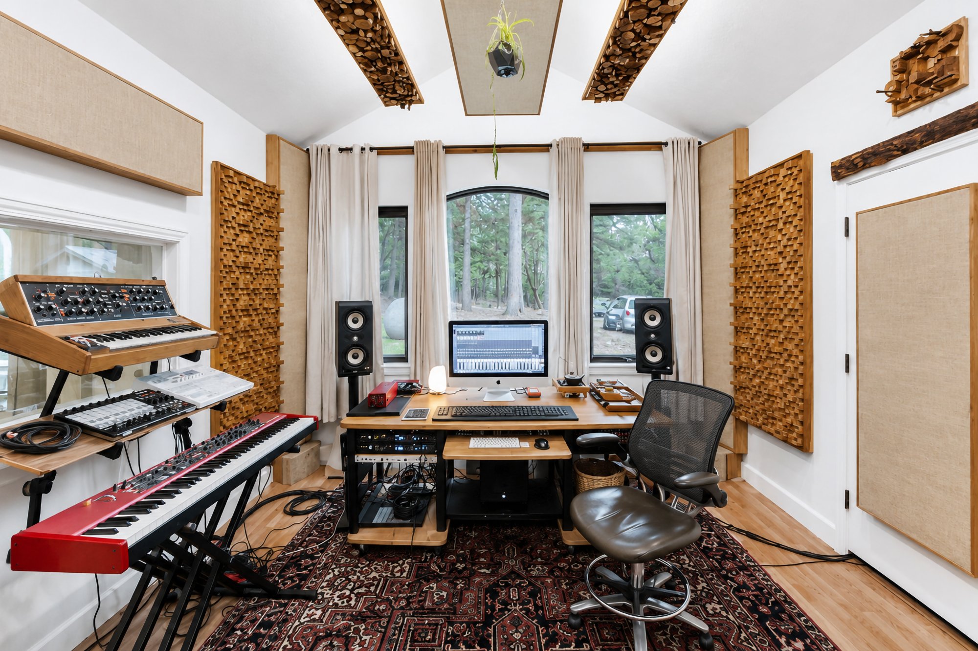 The control-room desk with a modular synth and keyboards beside the arched window